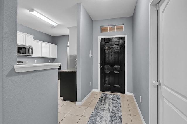 entrance foyer featuring light tile patterned floors and baseboards