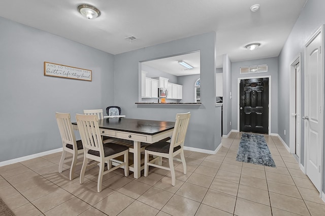 dining room featuring light tile patterned floors, visible vents, and baseboards