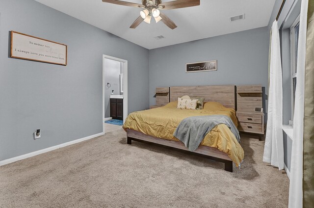 bedroom with baseboards, ensuite bath, visible vents, and light colored carpet