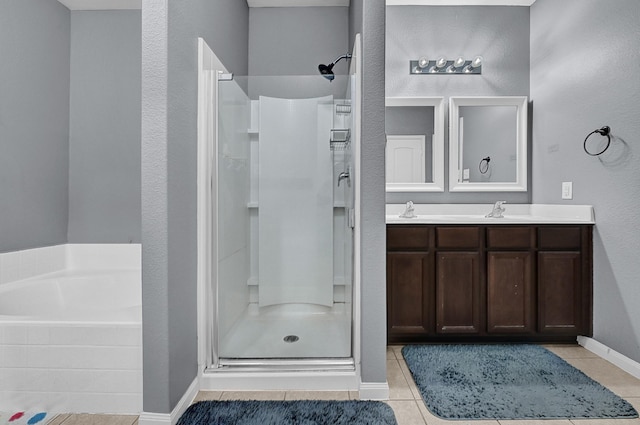 full bath featuring tile patterned flooring, a garden tub, a sink, and a shower stall