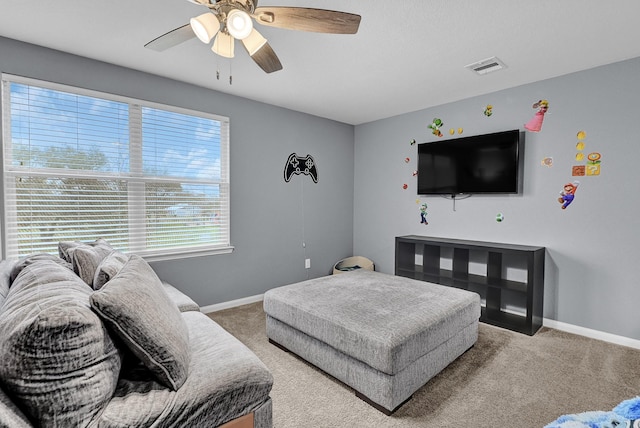 carpeted living area featuring visible vents, ceiling fan, and baseboards