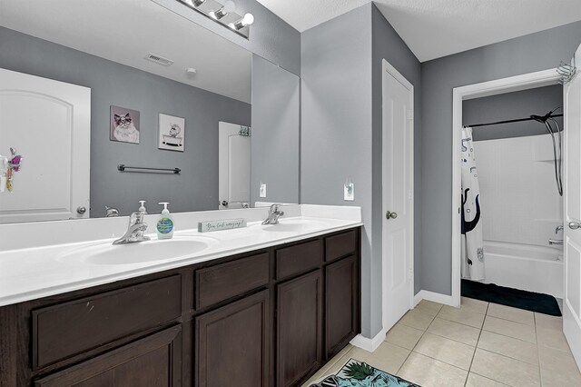 full bathroom featuring tile patterned flooring, shower / bathtub combination with curtain, visible vents, and a sink