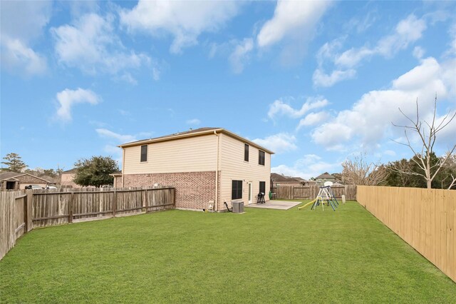 view of yard with a playground, a patio, a fenced backyard, and central AC unit