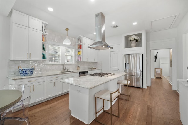 kitchen with island exhaust hood, open shelves, stainless steel appliances, white cabinets, and a sink