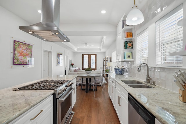 kitchen featuring light stone counters, island exhaust hood, appliances with stainless steel finishes, white cabinetry, and a sink