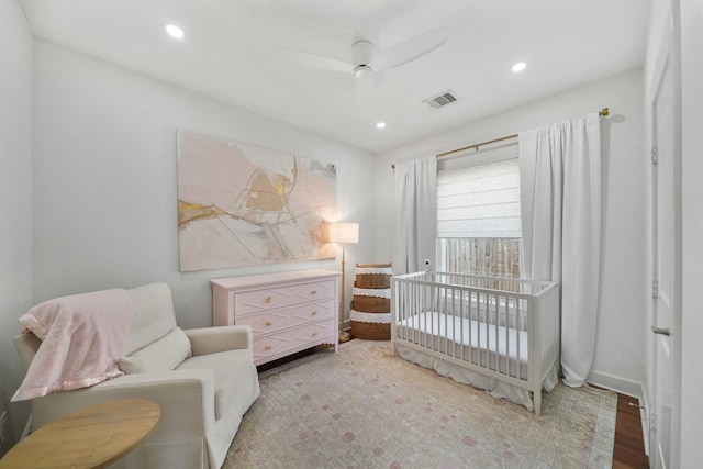 bedroom featuring a nursery area, a ceiling fan, visible vents, and recessed lighting