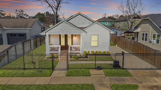 bungalow-style home with a porch, a gate, a yard, and a fenced front yard