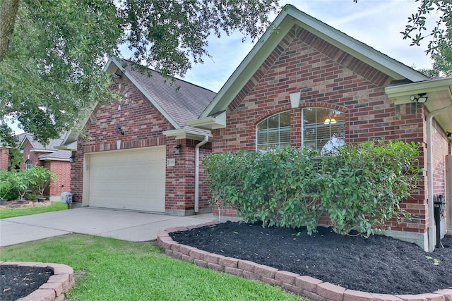 view of front of property featuring driveway, brick siding, roof with shingles, and an attached garage