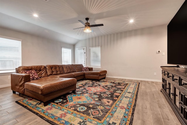 living area with light wood finished floors, baseboards, and a ceiling fan