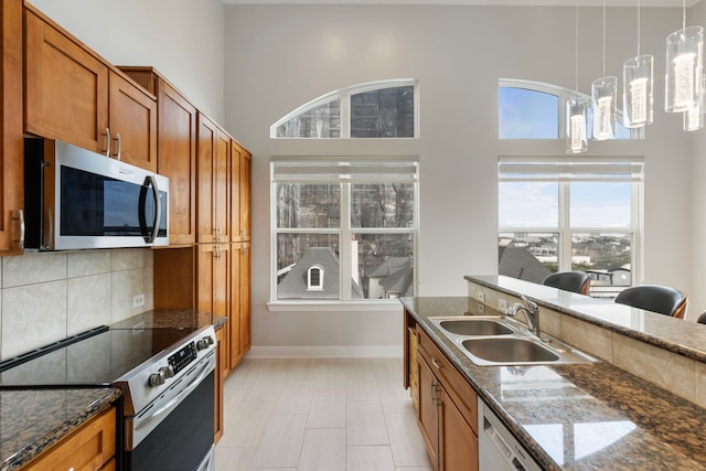 kitchen featuring appliances with stainless steel finishes, brown cabinets, and a sink