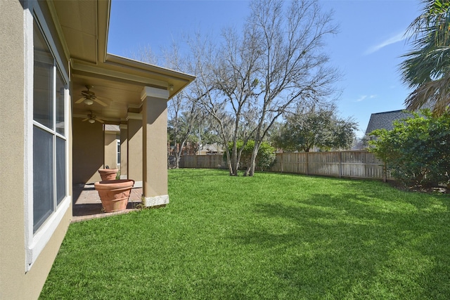 view of yard with a fenced backyard and ceiling fan