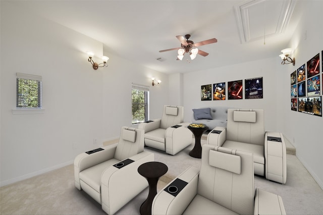 cinema room with a ceiling fan, light carpet, visible vents, and baseboards