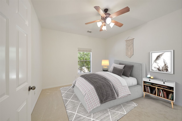 bedroom featuring baseboards, a ceiling fan, visible vents, and light colored carpet