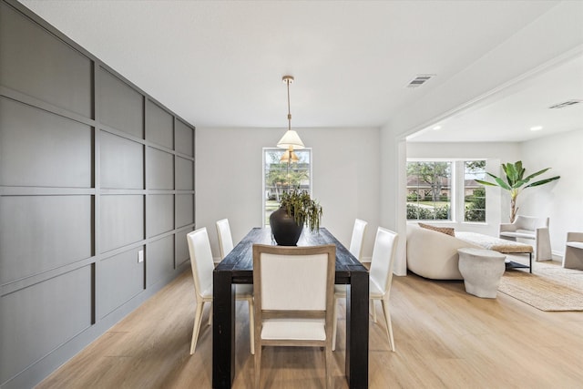 dining area featuring light wood-type flooring and visible vents