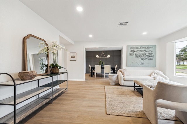 living area with baseboards, light wood-type flooring, visible vents, and recessed lighting