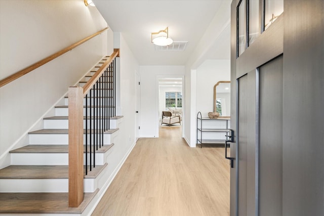 entrance foyer with baseboards, stairs, visible vents, and light wood-style floors