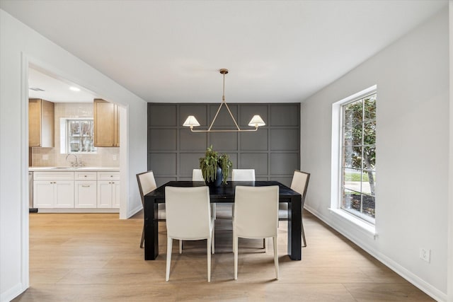 dining space featuring light wood finished floors, plenty of natural light, and a chandelier