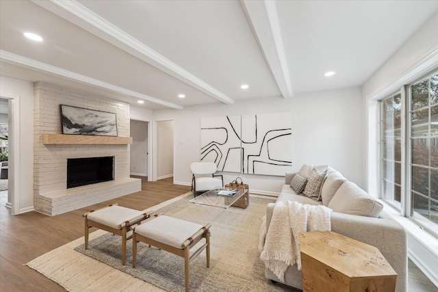 living room with recessed lighting, a fireplace, beamed ceiling, and wood finished floors