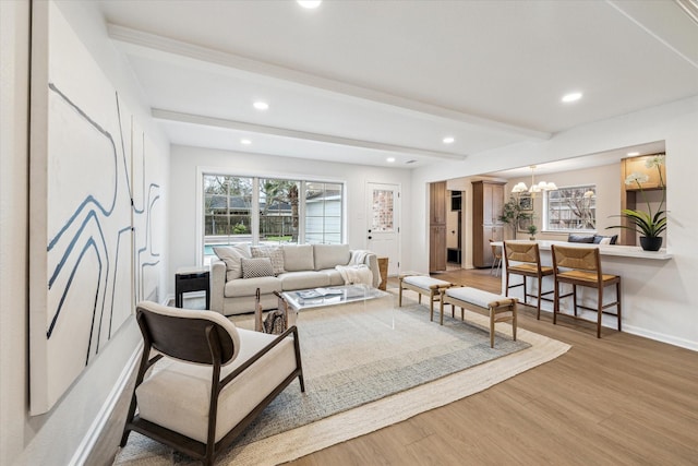 living room featuring a notable chandelier, recessed lighting, baseboards, beam ceiling, and light wood finished floors