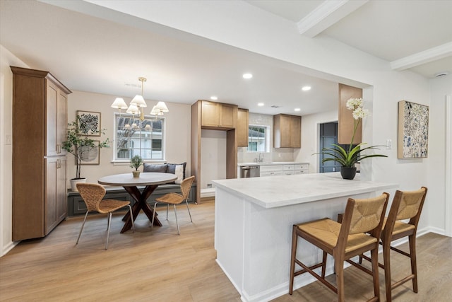 kitchen featuring recessed lighting, a peninsula, light wood-style floors, dishwasher, and brown cabinetry