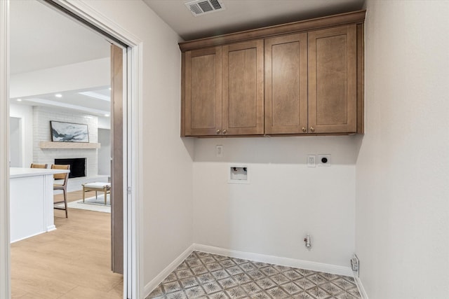 laundry room with visible vents, cabinet space, electric dryer hookup, and baseboards