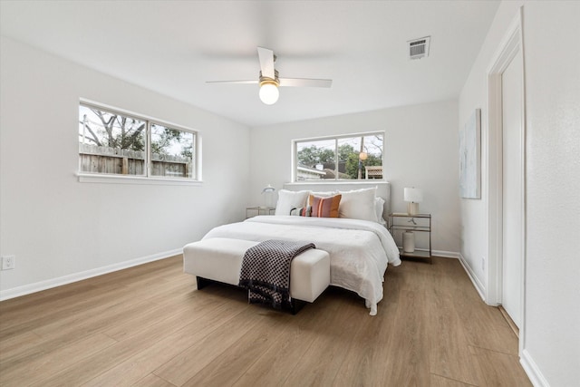 bedroom featuring light wood-style floors, visible vents, ceiling fan, and baseboards