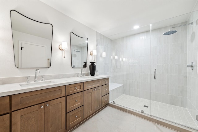 full bath with double vanity, marble finish floor, a shower stall, and a sink