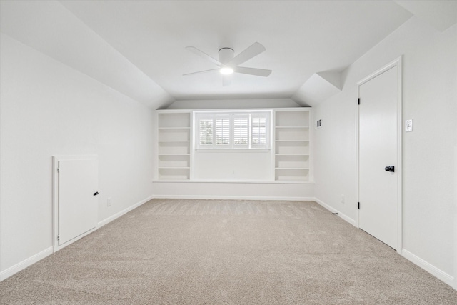 bonus room featuring vaulted ceiling, a ceiling fan, light colored carpet, and built in features