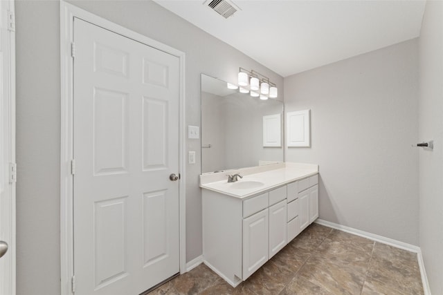 bathroom featuring vanity, visible vents, and baseboards