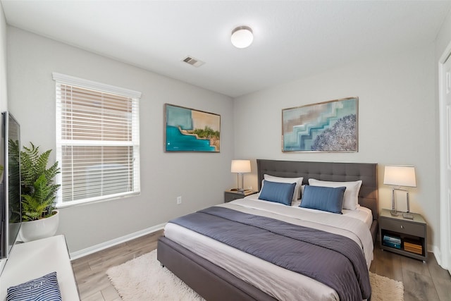 bedroom featuring light wood-type flooring, baseboards, and visible vents