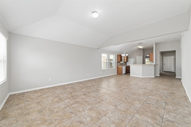 unfurnished living room featuring vaulted ceiling, baseboards, and a notable chandelier