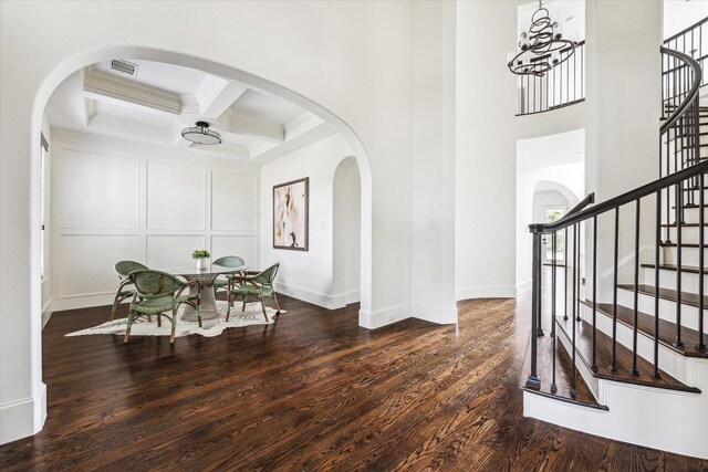 interior space with coffered ceiling, visible vents, stairs, beam ceiling, and dark wood-style floors