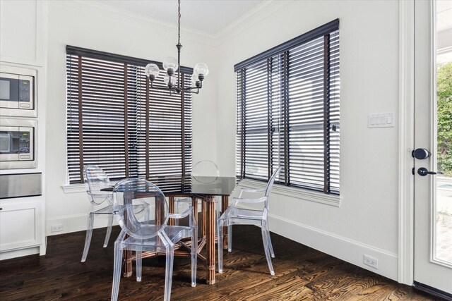 dining room with baseboards, ornamental molding, dark wood-type flooring, and a notable chandelier