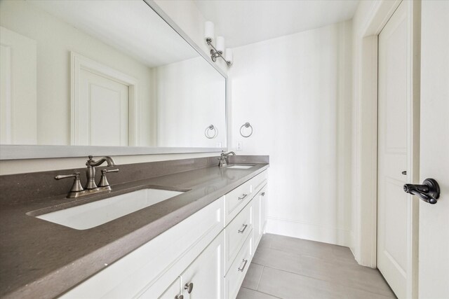 bathroom with tile patterned floors, a sink, and double vanity