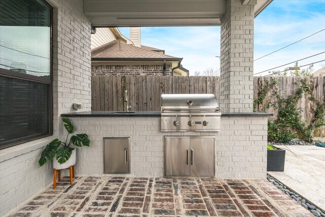 view of patio / terrace with a grill, an outdoor kitchen, and fence