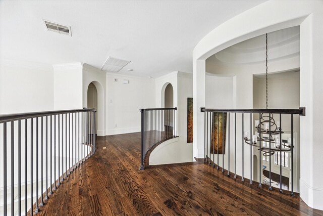 hall featuring ornamental molding, dark wood-style flooring, visible vents, and baseboards