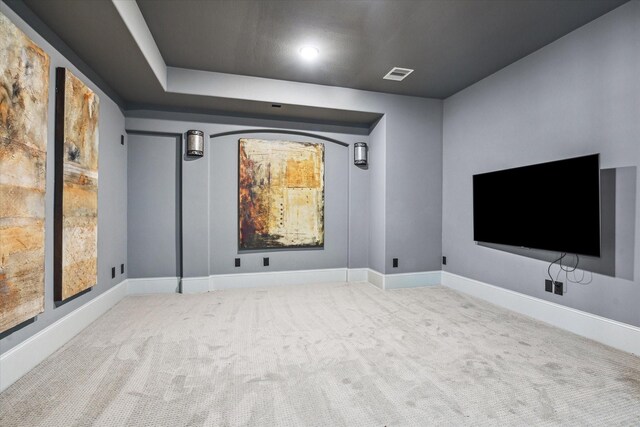 cinema room with light carpet, baseboards, and visible vents