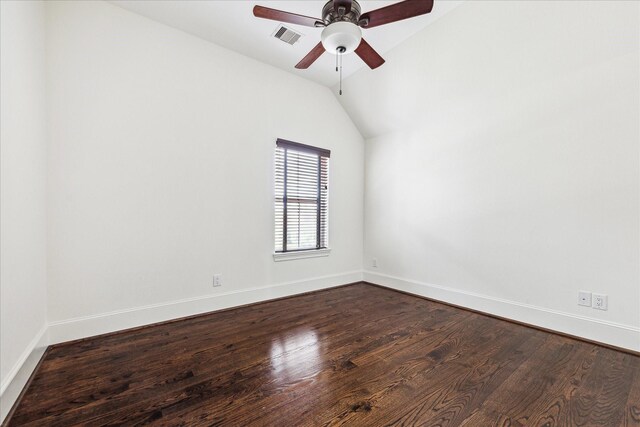 empty room with vaulted ceiling, wood finished floors, visible vents, and baseboards