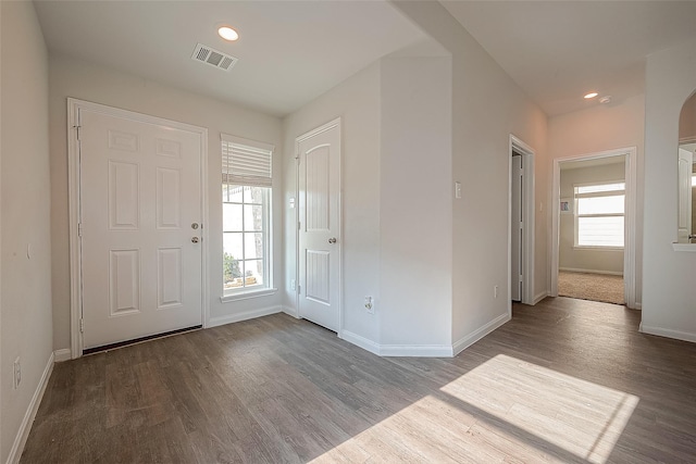 entrance foyer with visible vents, a healthy amount of sunlight, baseboards, and wood finished floors