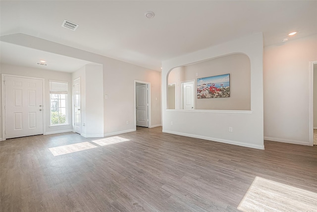 unfurnished living room with recessed lighting, wood finished floors, visible vents, and baseboards