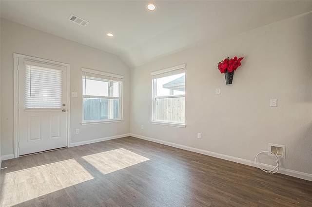 unfurnished room featuring visible vents, lofted ceiling, baseboards, and dark wood-style flooring