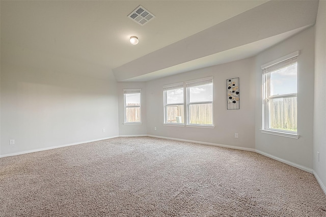 carpeted spare room featuring visible vents and baseboards