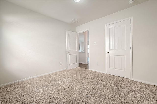 unfurnished bedroom with carpet, visible vents, and baseboards