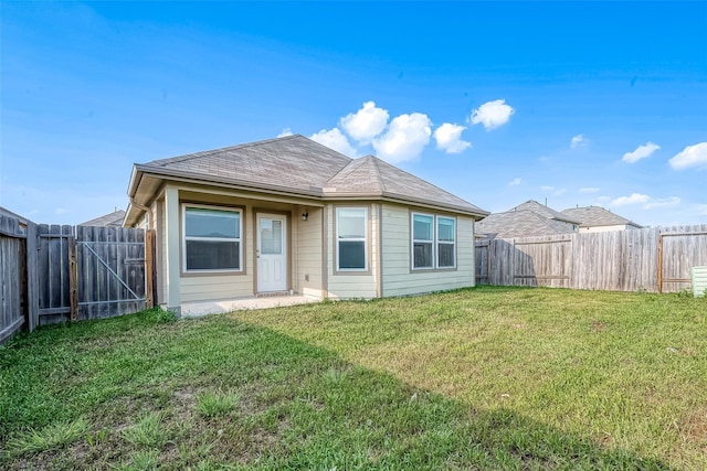 back of property featuring a lawn and a fenced backyard