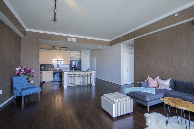 living room with dark wood-style floors, ornamental molding, visible vents, and wallpapered walls