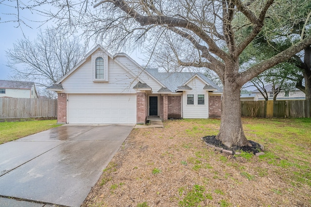 view of front of property featuring brick siding, concrete driveway, a front yard, fence, and a garage