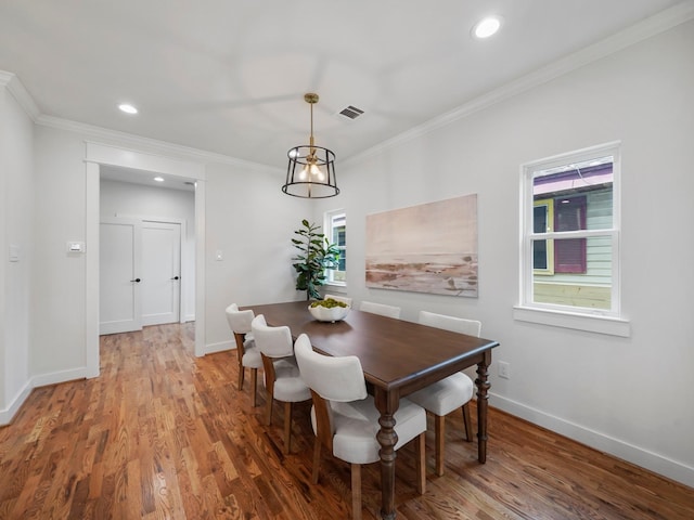 dining area with wood finished floors, visible vents, and baseboards