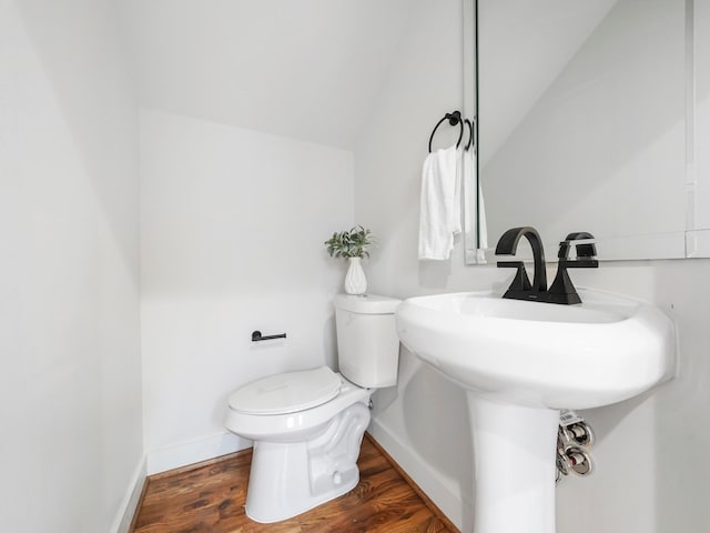 bathroom featuring lofted ceiling, baseboards, toilet, and wood finished floors