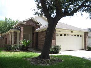 ranch-style house featuring driveway, a garage, a front lawn, and brick siding