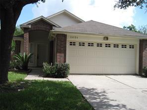 ranch-style house featuring an attached garage, concrete driveway, and brick siding